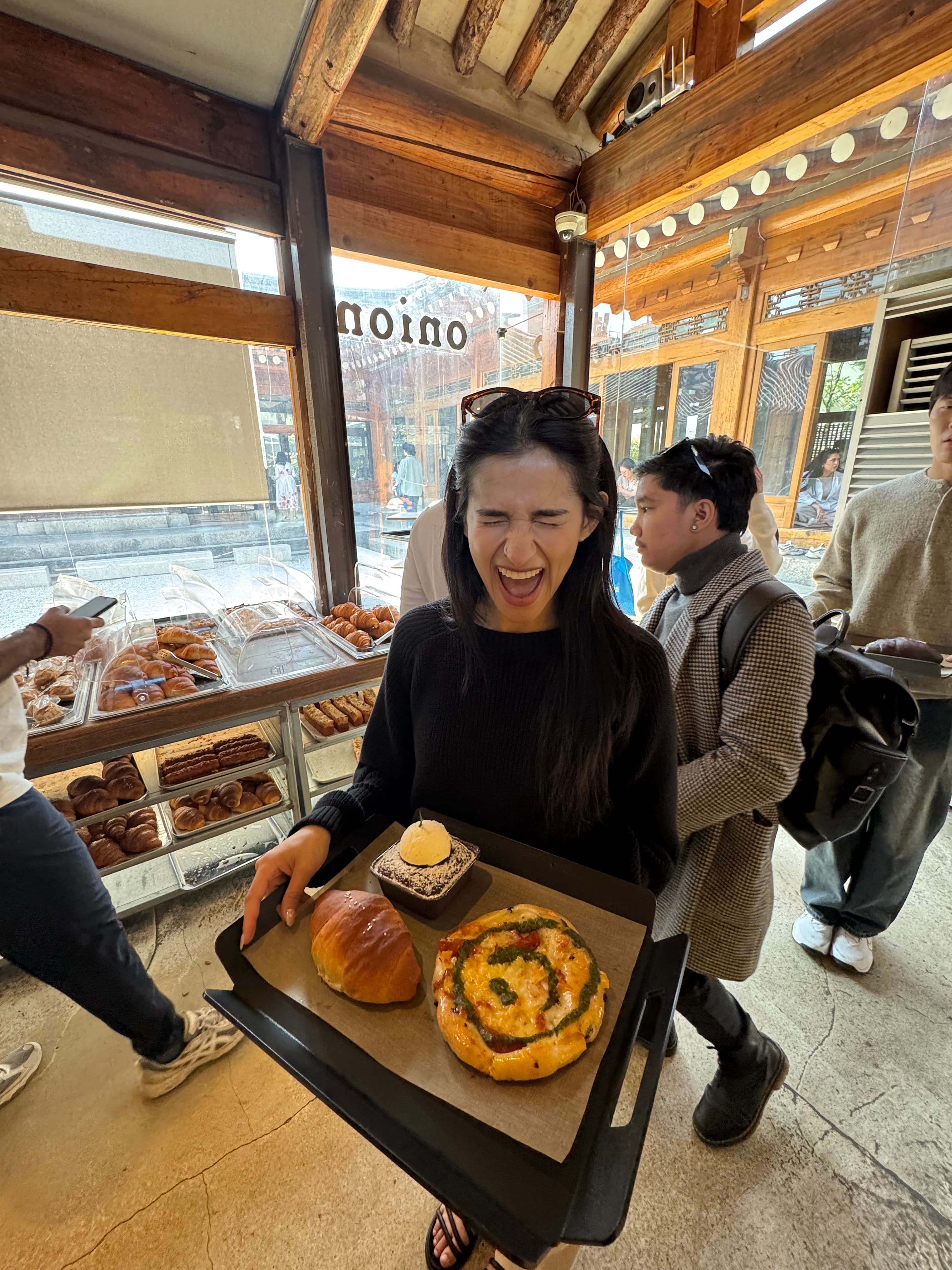 Lavi holding a tray of pastries at a café in Seoul